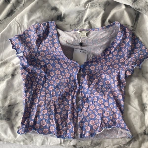 Blommig t-shirt  - Blommig t-shirt från Monki. Endast testad och prislappen sitter kvar. Säljer då jag inte gillade hur den satt på mig. (Jag säljer en likadan i svart)
