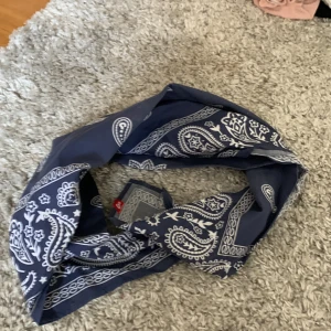 Blå hårscarf med vitt mönster - Blå hårscarf med vitt mönster. Aldrig använd.
