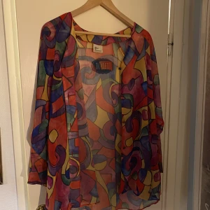 Genomskinlig kafkan - Genomskinlig, lång tröja/kappa/kafkan med knappar. I fint skick. Vintage. 