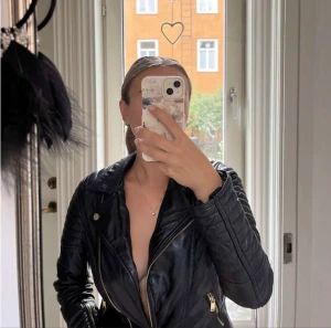 Bikerjcka - En svart skinnjacka (fake skinn) i ett tjockt material.