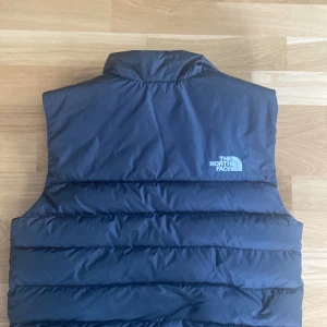 The North Face väst - En riktig snygg väst som säljs då den inte används längre. Den är i storlek S men skulle säga att den känns större än så. Väldigt tunn och skön men samtidigt varm! Bara att höra av sig vid frågar eller fler bilder. Köpt för 1600
