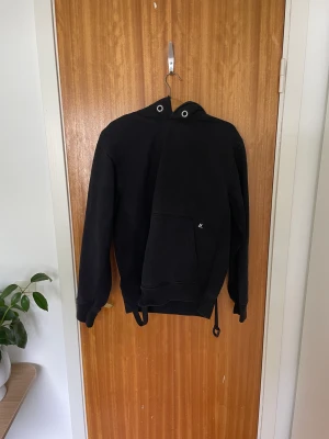 Helmut Lang Hoodie - Säljer denna snygga Helmut Lang hoodie. Inköpt på ssense för cirka 3 år sedan, men sparsamt använd. Banden bak på hoodien går att knäppa upp.