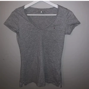 Tommy hilfiger tshirt - Tshirt med slits på sidorna från tommy hilfiger. Använd runt 3 gånger då det ej var min stil. Bra skick!