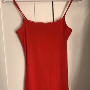 Röd klänning  - Fint skick aldrig använd, röd klängen med två lager ett genomskinligt och ett täckande lager stl s