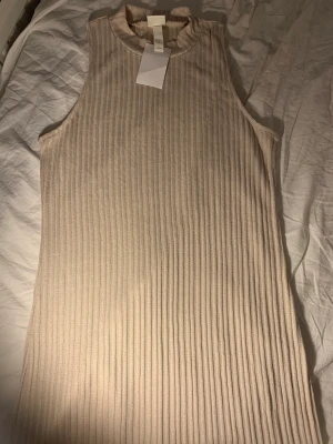 Klänning  - Helt ny klänning med prislapp kvar, den har en slits på sidan. 