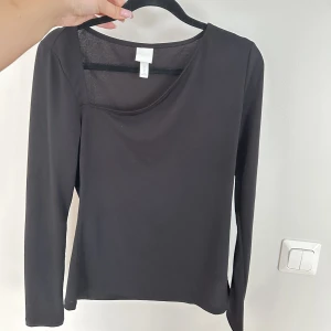 Svart topp - En oanvänd svart topp från HM med en fin skurning framtill. 