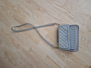 Axelremsväska - Grå axelremsväska med nitar från River Island. Knappt använd. 