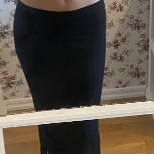 Lång/penn kjol med två små slitsar - Svart kjol i nyskick endast använd en gång. Två små slitsar på sidorna
