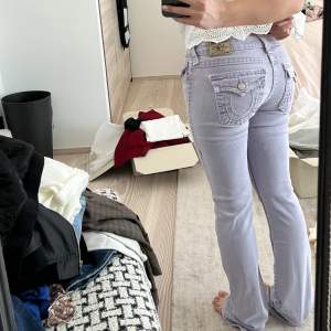 Super coola och unika true religion jeans! Dem är bootcut och lågmidjade. Färgen är ljus/pastell lila. Väldigt bra skick! Som nya.  Storleken kan jämföras med en 36-38. Jag är ca 160 lång. Innerbenslängd: 82cm. Midjemått: 36 cm rakt över, alltså diametern