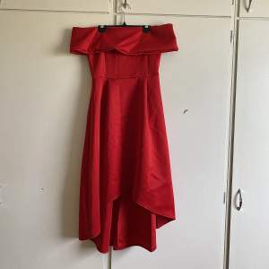 Röd klänning med asymmetrisk kjol, sitter tight med medel stretch 