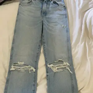 Ett par blåa jeans med hål Knappast använda