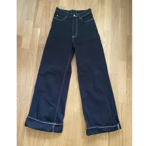 Svarta jeans Lee - Säljer dessa superfina unika utsvängda jeans från Lee i stl XS/32. De var vita från början, men färgades för att vara svarta istället. Vita sömmar och lila logga på baksidan. Mycket fint skick :) skriv om du har frågor✨