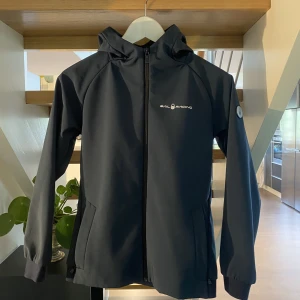 Sail racing jacka  - Säljer en blå sail racing jacka i storlek 160. Säljs pga För liten, två yterfickor två innerfickor samt åtdragbar luva, 399:-