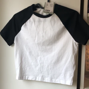 Svartvit t-shirt  - En super fin svartvit t-shirt från HM som är i strl M fast passar mig som har S/XS. Den är helt ny så den är inte använd och som ni ser sitter lappen kvar. Den kostade 70 kr ny mitt pris är 40 kr + frakt pris kan diskuteras, dma vid intresse. Tryck inte p