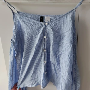 Blå topp  - Lite svårt på bild, men en blå randig topp med öppna axlar. Är ifrån H&M i storlek 32.