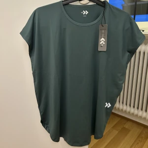 Grön träningst-shirt - Storlek XS, aldrig använd. 50kr.
