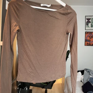 Brun långärmad topp - Brun tajt långärmad topp från NAKD. Väldigt skönt och tunt material som sitter fint på kroppen. 