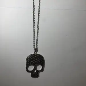Ett silver halsband med en stor dödskalle på, som är köpt på secondhand💗