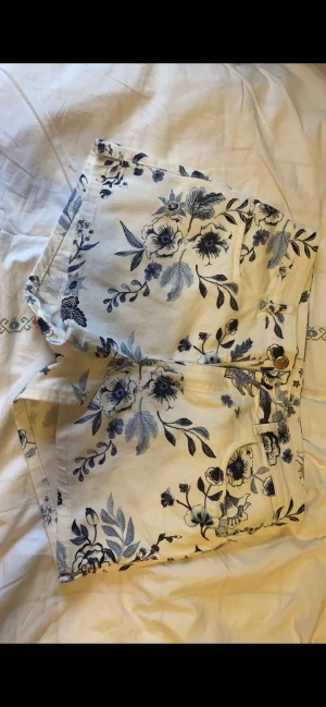 Jeans shorts - Jättefina jeansshorts med små blåa blomdetaljer som ger byxorna en super sommrig vibe🌻☀️Inte använda och är därför i superbra skick! Kostade 250kr i butik säljer nu för 169k. Är i strl 170 men skulle hellre säga xxs-xs💘