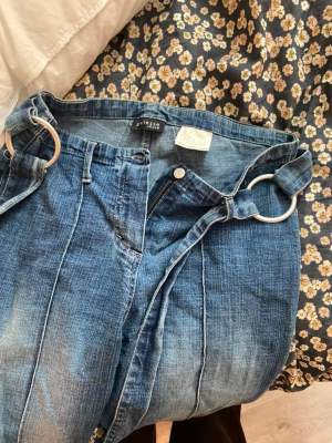 Vintage Y2K jeans, utsvängda med knytdetalj i midjan. Stretchiga. Uppskattningsvis st.34-38.