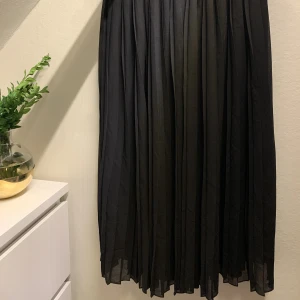 Medellång kjol - Svart medellång kjol (slutar under knäna på mig) med resår i midjan. Knappt använd.