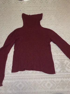 Stickad tröja - Vinröd Stickad tröja med något flarie armar. Från märket Stockholm i storlek S. Bra skick men tecken på användning. 