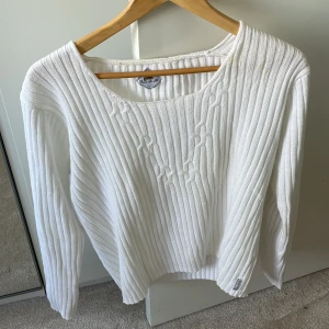 Vit stickad tröja - En enkel vit stickad tröja med vid halsring. Några få fläckar på vänster axel, annars bra skick.