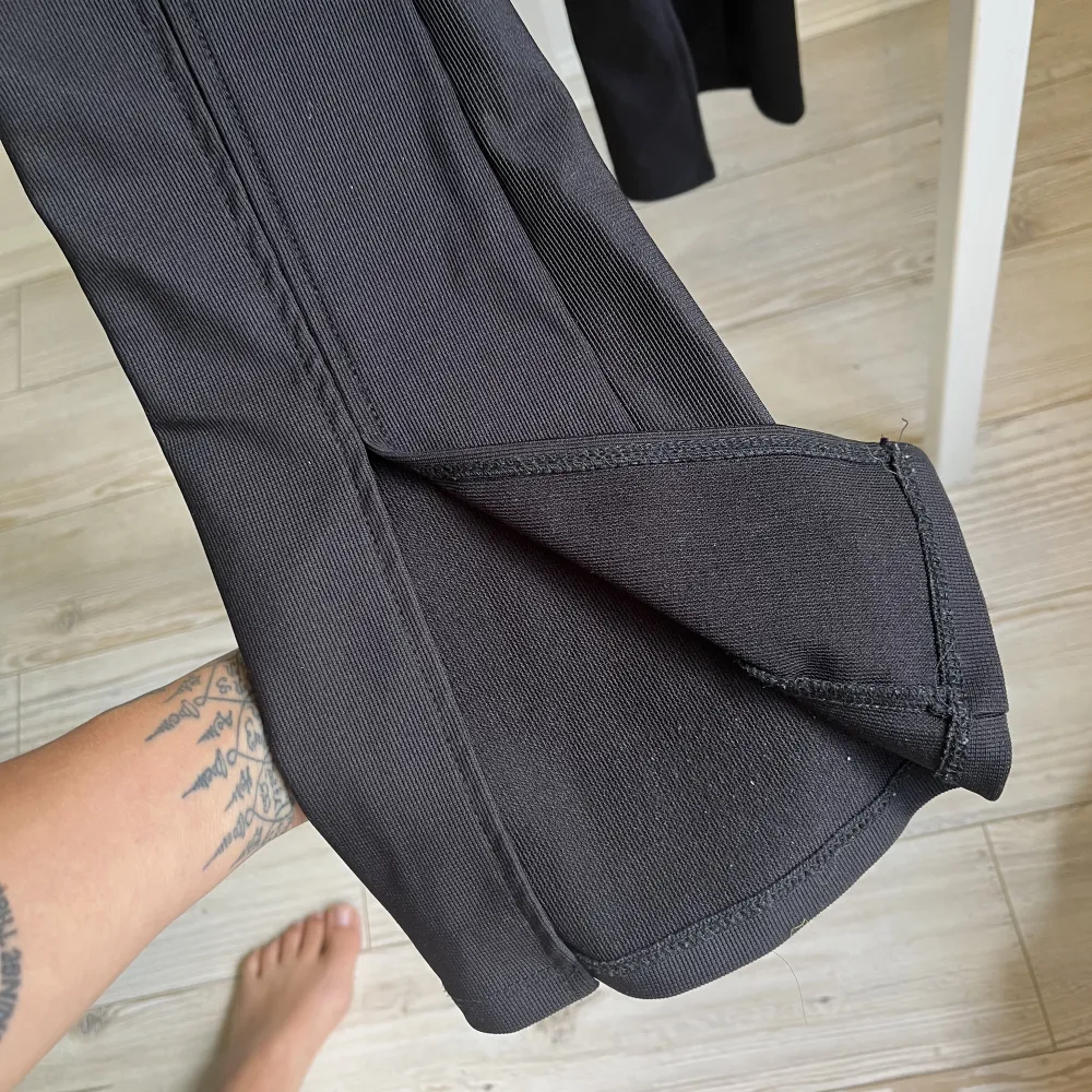 Svarta kostymbyxor med slitz vid fötterna. Jeans & Byxor.