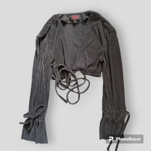 Svart blus  - En jättefin svart blus som har långa ärmar och ett långt snöre som man kan knyta flera gånger runt. 