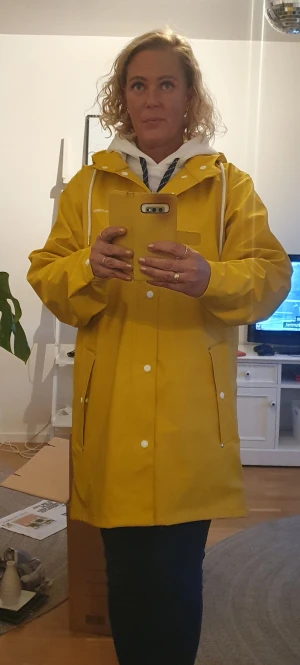 Gul Tretorn regnjacka Medium  - Oanvänd dvs nyskick endast provad regnjacka från Tretorn. Gul storlek M. Två fickor framtill tryckknappar vid ärmslut beroende på hur tight man vill ha den. Lite längre baktill än fram. Går att knäppa upp i halsen rejäl luva. 500kr 