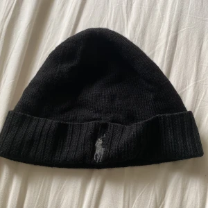 Ralph Lauren mössa- svart - Svart ullmössa från Polo Ralph Lauren, loggan är broderad i grått.