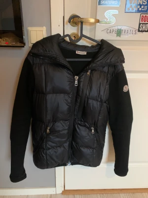Moncler cardigan/koft-jacka - Moncler cardigan i storlek 3(ungefär en medium) Inga hål eller fläckar, tyget är lite nopprigt, och bilden där inne är lite blekt, annars fina skick. Cond 6/10 ungefär Kan fraktas!
