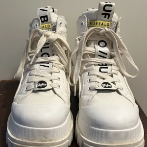 Buffalo kängor  - Vita Buffalo kängor, använda några gånger som man kan se på sulan.  Förutom detta är dom i väldigt bra skick. 