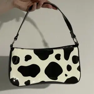 En liten fin handväska med ko-mönster✨ Knappt använd, köpt via secondhand. Det finns en liten repa, men annars fint skick!