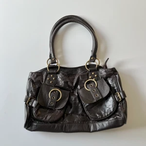 Brun väska - Brun rymlig väska. Längd: ca 33 cm. Bredd: 20 cm. Djup: 10 cm 💕