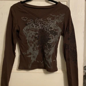 Långärmad t-shirt med tryck - Brun långärmad T-shirt med coola tryck. Aldrig använd.