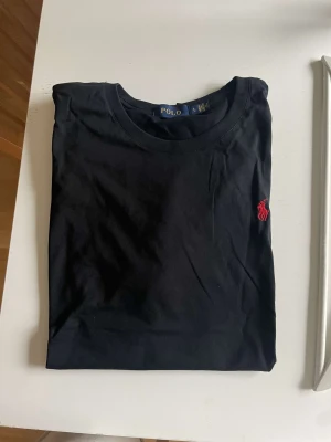 Polo T-Shirt - Svart Polo T-shirt med röd logga Oanvänd, pris kan diskuteras!
