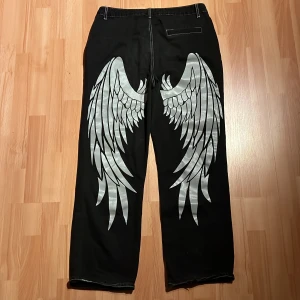 Angel wing print jeans - Anotha random brand feta jeans med tryck🤤🐊säljer cheap cause tags missing again💯😈no big flaws utom små fläckar som prob går bort i tvätten💯skriv privat för frågor🙏pris går att diskuteras‼️KÖPARE STÅR FÖR FRAKT‼️