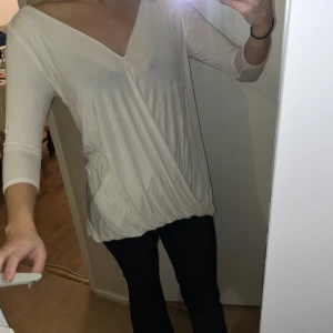 Topp  - Nästan helärmad (se bilder). Ett tunt gummiband längst ner så man kan själv justera hur lång/kort man vill ha toppen. På bilderna har jag det längsta man kan ha. Står storlek S men är mer som en L eller liten XL. Skrynklig då den legat i en väska.