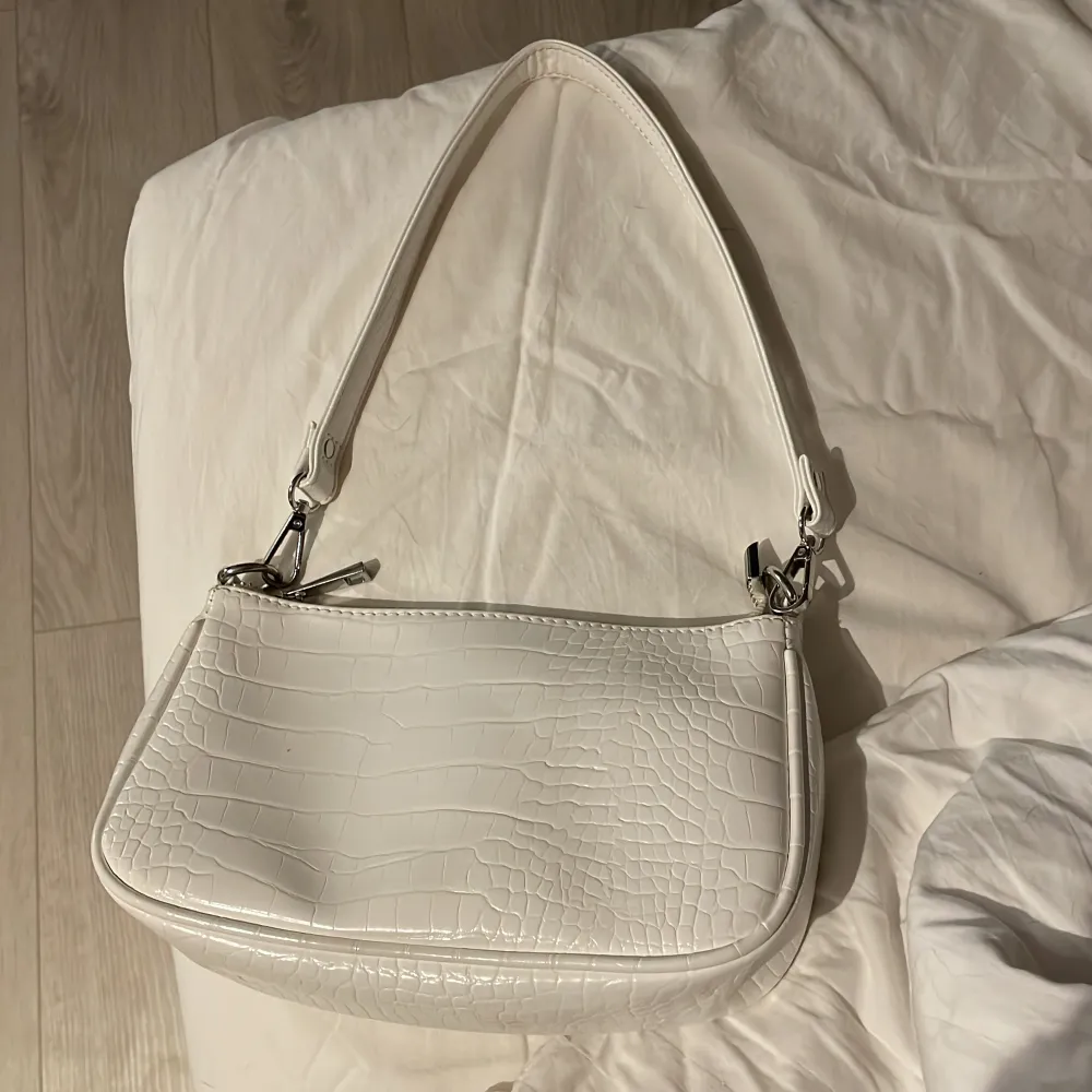 En vit handväska från Gina tricot som är i nått slags fake skinn . Accessoarer.