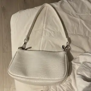 En vit handväska från Gina tricot som är i nått slags fake skinn 