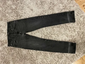 Svarta straight jeans - Svarta straight midwasted jeans från lee med fina detaljer på fickorna där bak