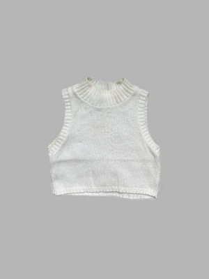 Stickad benfärgad väst - En croppad benfärgad väst från Asos. Lite missfärgad därav priset. Storlek 36. 75% akryl 25% nylon.