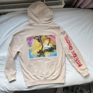Kanye West Kids See Ghosts Hoodie - En sjukt fet Kanye West Kids See Ghosts Hoodie i en beigeish färg. Den har ett fett tryck av albumets coverart på ryggen, ”kids see ghosts” på vänstra ärmen och lite text högra bröstet. Inga defekter, endast ”luvsnören” saknas. Köpt second-hand. Läs bion