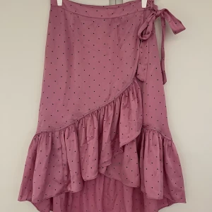 Prickig kjol - Rosa Satinkjol med svarta prickar, knyts som omlott. Strl S från vero Moda 