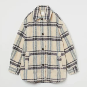 Skjortjacka I Pile Ljusbeige/grårutig - Superfin jacka endast använd 2 ggr och säljs nu då den är lite för stor.  En skjortjacka i mjuk pile. Jackan har krage och knäppning samt stolpfickor fram. Nedhasad axel och lång ärm med manschett och knäppning. Okavskärning med motveck bak. Fodrad.