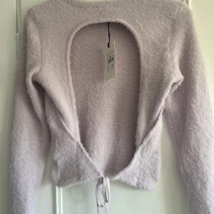 Långärmad  - En ljuslila lurvig tröja med öppen rygg. Från Bikbok. Strl M. Oanvänd med prislapp kvar! 60 kr 💜 Köparen betalar frakten och betalning sker endast via swish! 