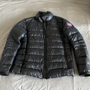 Canada Goose Crofton Jacket Dunjacka Black/Svart - Crofton jacket black XL 180/116Y Mint kondition jacket apart from two tiny holes, whereas one of them is patched up and the second mark is so small that it has been left unattended. Jacket to big for me nowdays. Worn during this winter. Smooth trades only
