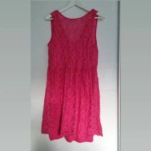 Rosa spetsklänning  - Fin rosa spetsklänning med innerklänning, sparsamt använd. Är jättefin med ett bredare bälte till. Kan användas på bägge håll men meningen är att urringningen ska vara på ryggen. Bilderna gör inte färgen riktigt rättvis men snarlik.