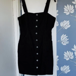 Hängsleklänning - Fin hänglseklänning i manchestertyg. Säljer då den blivit för stor på mig. Använd ett fåtal gånger, gott skick på klänningen. 